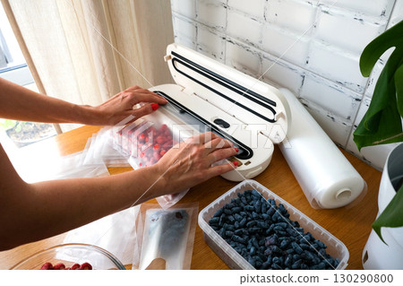 Vacuum sealer of strawberries, honeysuckle in bag, packaging for long-term storage . Vacuum packing machine 130290800