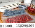 Vacuum sealer of strawberries, honeysuckle in bag, packaging for long-term storage . Vacuum packing machine 130290804