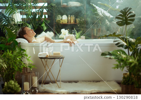 Woman Relaxing in a Lush Green Bathroom Bathtub Woman Relaxing in a Lush Green Bathroom Bathtub 130290818