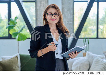 Portrait of smiling middle-aged confident business woman with notebook Portrait of smiling middle-aged confident business woman with notebook 130290916