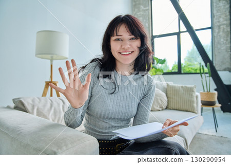 Web cam view of young woman with papers, online meeting, video call 130290954