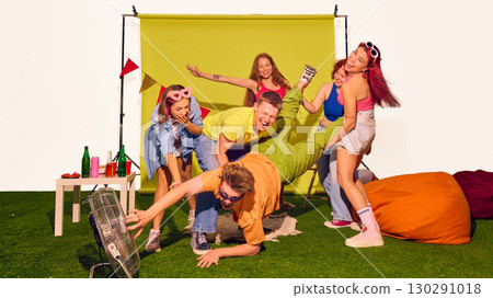 Friends holding one person by legs as he reaches toward fan laughing Friends holding one person by legs as he reaches toward fan laughing 130291018