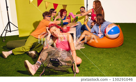 Group of friends sitting on grass with pizza and drinks enjoying summer party mood Group of friends sitting on grass with pizza and drinks enjoying summer party mood 130291046