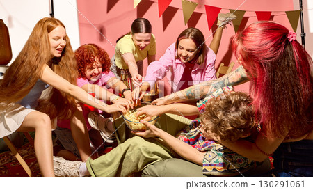 Group of young friends fighting for snacks at lively party with joyful energy Group of young friends fighting for snacks at lively party with joyful energy 130291061
