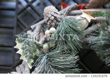 Christmas wreath with branches and silver balls on a glass door Christmas wreath with branches and silver balls on a glass door 130291876
