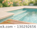 Sunlit Pool Steps With Turquoise Water And Wooden Deck 130292656