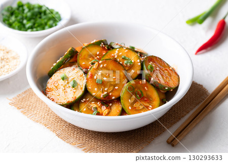 Korean cucumber salad (Oi muchim) in bowl on white background, Korean side dish Korean cucumber salad (Oi muchim) in bowl on white background, Korean side dish 130293633