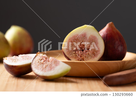 Fresh fig on wooden plate and cutting wooden board with black background, Autumn fruit Fresh fig on wooden plate and cutting wooden board with black background, Autumn fruit 130293660