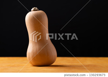 Fresh butternut squash pumpkin on orange and black background 130293673