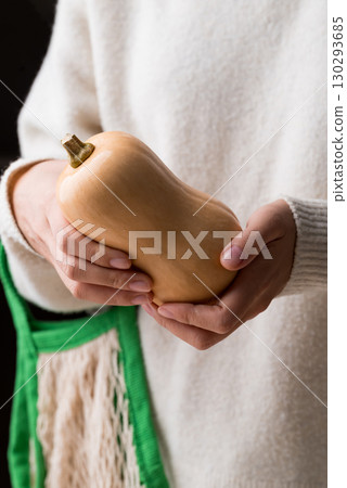 Butternut squash pumpkin holding by woman hand Butternut squash pumpkin holding by woman hand 130293685