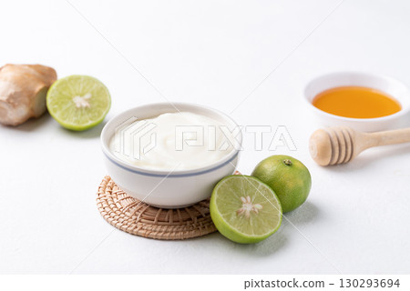 Yogurt, lime, honey and ginger on white background Yogurt, lime, honey and ginger on white background 130293694