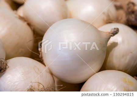 Fresh onions. Onion background. Ripe onions. Onions at the market, lying in a beautiful pile, fresh harvest from the farm 130294815