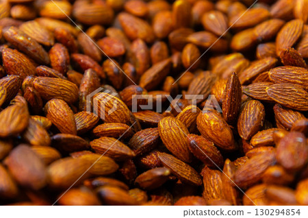 Almond background. Almonds top view background. Whole almond nuts flat lay. Full depth of field. Perfect not AI almond, true photo 130294854