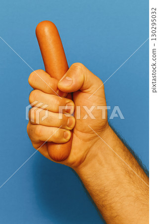 hand gripping sausage on blue, generative AI 130295032
