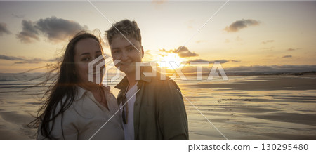 Lesbian couple enjoying romantic sunset on beach 130295480