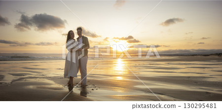 Lesbian couple holding hands and enjoying golden sunset on beach 130295481