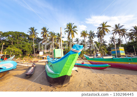 Fishing boats rest on the beach in Arugam Bay, Sri Lanka 130296445