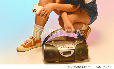 Retro boombox on floor with smartphone in hand 130296757
