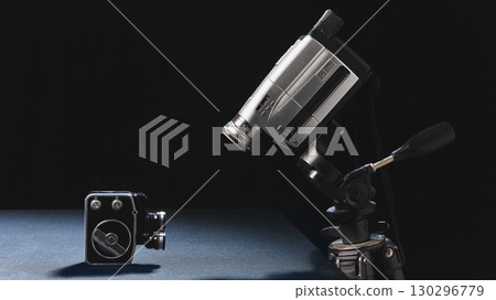 Vintage and modern video cameras facing each other in symbolic contrast Vintage and modern video cameras facing each other in symbolic contrast 130296779