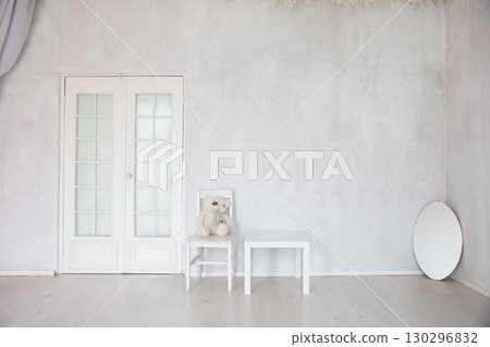 Chair, table and mirror in the interior of an white room with a door 130296832