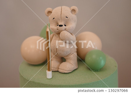 Adorable Teddy Bear with Candle on Pastel Cake, Birthday Celebration, Cute Animal Theme, Soft Colors, Bakery Decoration, Festive Event. 130297066