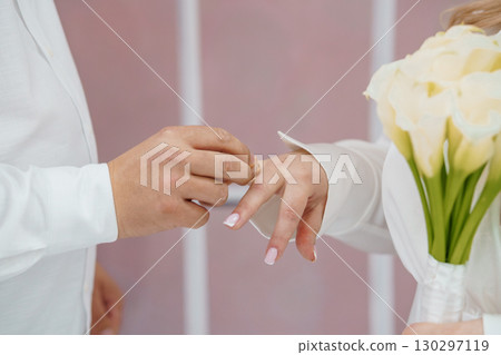 Wedding Ceremony Exchange Rings Close Up, Romantic Love, White Florals, Pink Backdrop, Elegant Couple, Commitment Symbol, Bridal Flowers Wedding Ceremony Exchange Rings Close Up, Romantic Love, White Florals, Pink Backdrop, Elegant Couple, Commitment Symbol, Bridal Flowers 130297119