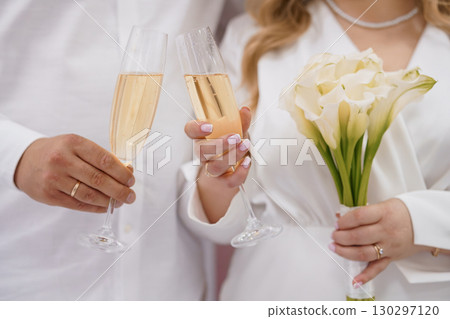Romantic Wedding Celebration Toast with Champagne and White Callas, Close-Up Elegant Love, Luxury, Partnership, White Flowers, Golden Bubbles. Romantic Wedding Celebration Toast with Champagne and White Callas, Close-Up Elegant Love, Luxury, Partnership, White Flowers, Golden Bubbles. 130297120