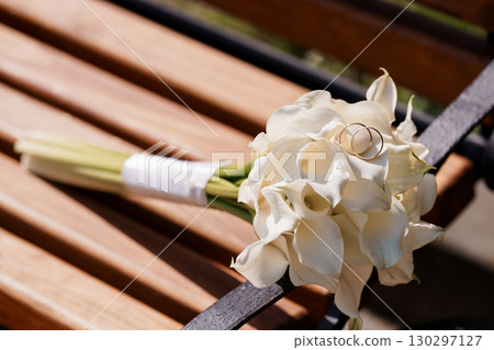 Wedding Bouquet of White Calla Lilies with Rings on a Wooden Bench, Romantic Scene, Sunlight, Love, Celebration, Floral Arrangement, Fine Art Photography Wedding Bouquet of White Calla Lilies with Rings on a Wooden Bench, Romantic Scene, Sunlight, Love, Celebration, Floral Arrangement, Fine Art Photography 130297127