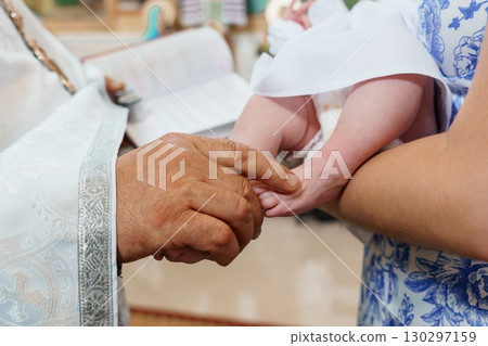 Orthodox Christian Baptism Ceremony: Priest Blessing Baby's Foot, White Robes, Sacred Book, Church Interior, Solemn Religious Ritual Orthodox Christian Baptism Ceremony: Priest Blessing Baby's Foot, White Robes, Sacred Book, Church Interior, Solemn Religious Ritual 130297159