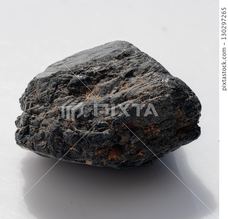 Polished Black Tourmaline Crystal Stone on White Background. Dark Mineral Specimen, Natural Gemstone, Jewelry Making, Healing Crystals, Textural Detail Polished Black Tourmaline Crystal Stone on White Background. Dark Mineral Specimen, Natural Gemstone, Jewelry Making, Healing Crystals, Textural Detail 130297265