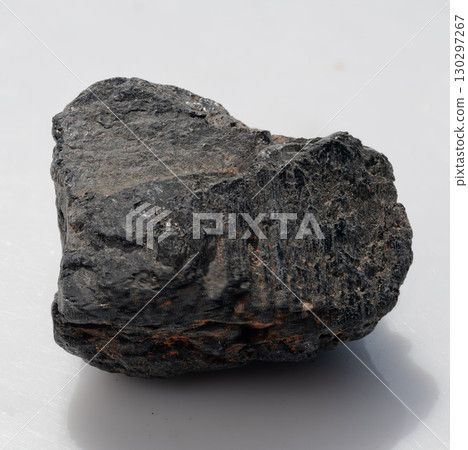 Rough Black Tourmaline Crystal Specimen Isolated on White Background, Dark Mineral, Geology, Gemstone, Natural Stone Texture, Shadow Detail 130297267