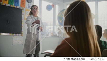 Female Doctor Visiting Classroom, Giving Lecture to Curious Primary School Students About Health and Hygiene Female Doctor Visiting Classroom, Giving Lecture to Curious Primary School Students About Health and Hygiene 130297432