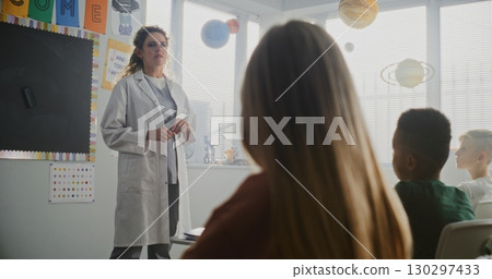 Female Doctor Visiting Classroom, Giving Lecture to Curious Primary School Students About Health and Hygiene Female Doctor Visiting Classroom, Giving Lecture to Curious Primary School Students About Health and Hygiene 130297433