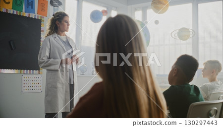 Female Doctor Visiting Classroom, Giving Lecture to Curious Primary School Students About Health and Hygiene 130297443