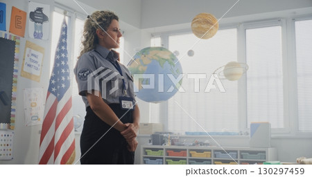 American Female TSA Security Officer Explaining Safety Rules to Young Students at Elementary School 130297459