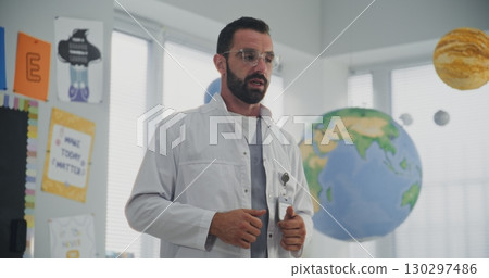 Male Healthcare Professional Explaining Dental Care Rules to Curious Young Students 130297486