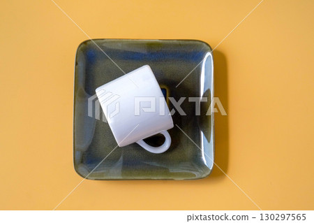 Ceramic mugs and plates on color background. Ceramic mugs and plates on color background. 130297565