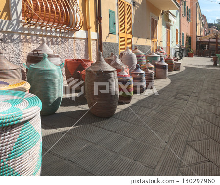 Traditional woven African baskets on street of old town in Italy. Private business, market and sales. Objects for kitchen, home, handmade. 130297960
