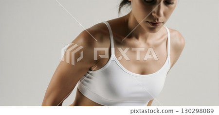 Woman in white sports bra posing for activewear and fitness fashion concept 130298089