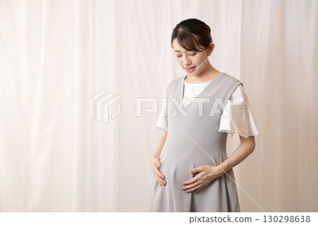 An eight-month pregnant woman holding her stomach 130298638