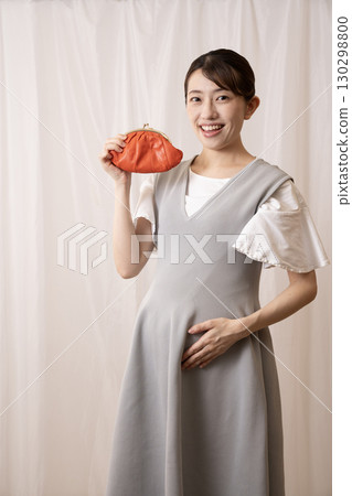 一位微笑的八個月孕婦拿著紅色錢包 130298800
