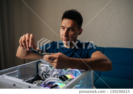 Skilled computer technician inserting wireless network module inside custom desktop computer, enhancing system connectivity for reliable internet performance. Concept of modern technology. 130298815