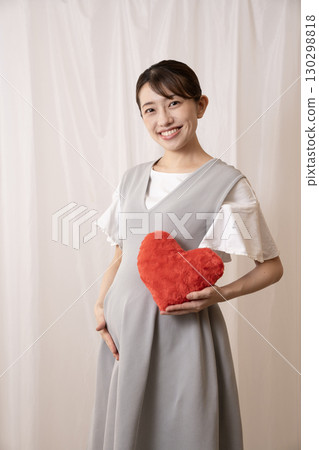 八個月的孕婦拿著一顆紅心 130298818