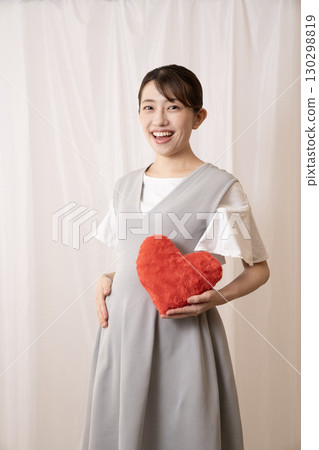 八個月的孕婦拿著一顆紅心 130298819