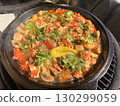 Beef meat and vegetables stew in black bowl with roasted baby potatoes. Dark background grill kamado. 130299059