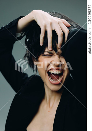 expressive woman screaming with hand in hair, dramatic emotion, dark outfit, intense mood expressive woman screaming with hand in hair, dramatic emotion, dark outfit, intense mood 130299273