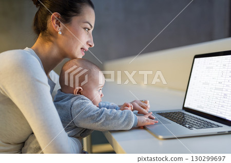 Working mom with baby touching laptop keyboard. Working mom with baby touching laptop keyboard. 130299697