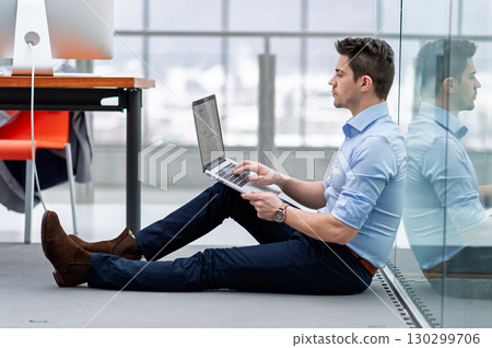 Young engineer working in office, sitting on floor. 130299706