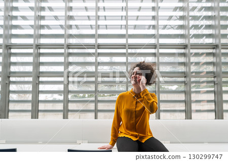 Woman making phone call in modern office. 130299747