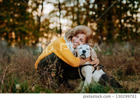 Older woman with his dog in autumn nature. 130299781